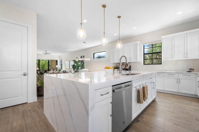 kitchen featuring white cabinetry, a center island with sink, stainless steel dishwasher, and sink