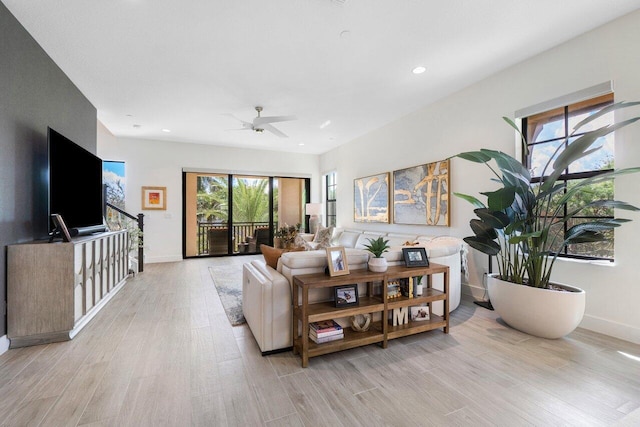 living room with light hardwood / wood-style floors and ceiling fan