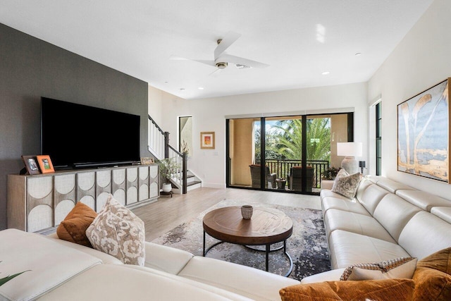 living room featuring light hardwood / wood-style floors and ceiling fan