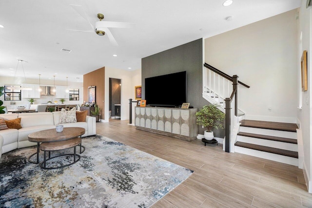 living room featuring ceiling fan and light hardwood / wood-style flooring