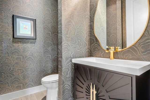 bathroom featuring toilet, hardwood / wood-style floors, and vanity