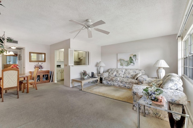 carpeted living room featuring a textured ceiling and ceiling fan