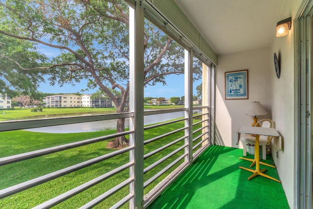 sunroom featuring a water view