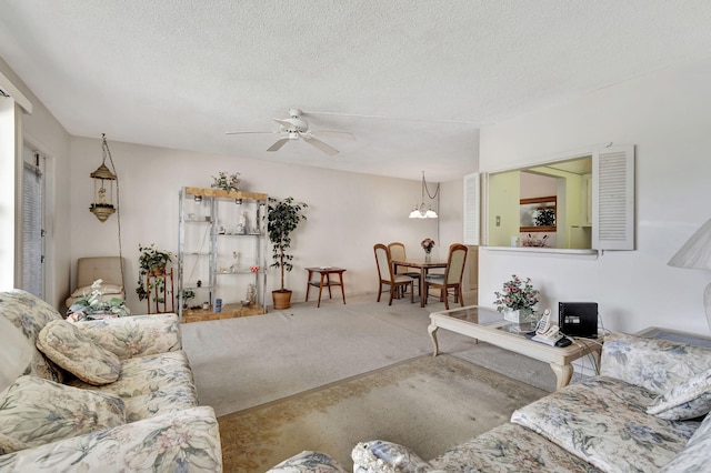 carpeted living room with ceiling fan with notable chandelier and a textured ceiling