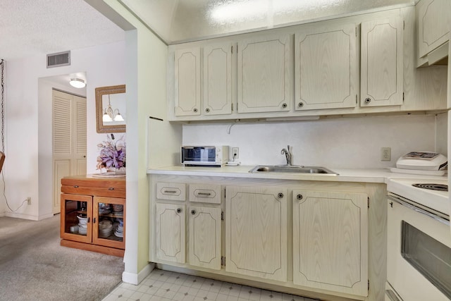 kitchen with white range with electric cooktop, light carpet, sink, and a textured ceiling