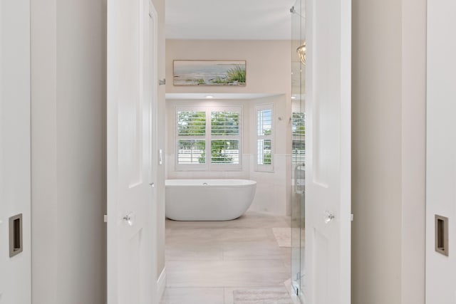 bathroom featuring tile patterned floors and shower with separate bathtub