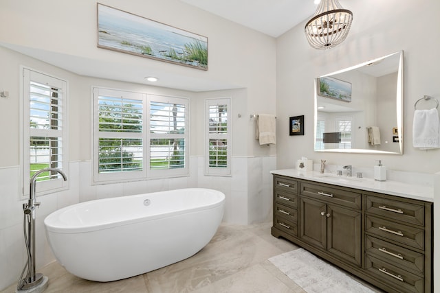 1464 Stallion Dr, Loxahatchee, FL 33470 - bathroom featuring vanity, a freestanding bath, a wainscoted wall, a chandelier, and tile walls
