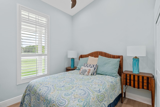 bedroom with ceiling fan, hardwood / wood-style flooring, and lofted ceiling