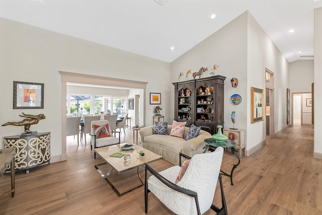 living room with hardwood / wood-style flooring and high vaulted ceiling