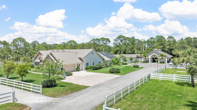 exterior space featuring a rural view, a front yard, and a garage