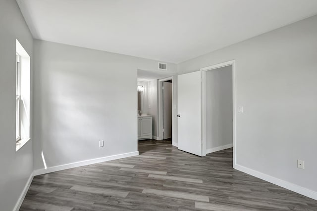 3200 SE Aster Ln Unit S-102, Stuart, FL 34994 - unfurnished bedroom with baseboards, dark wood-type flooring, and ensuite bathroom