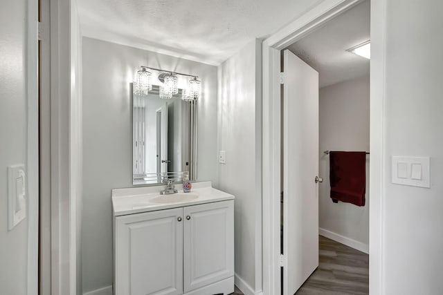 3200 SE Aster Ln Unit S-102, Stuart, FL 34994 - bathroom featuring vanity, wood finished floors, baseboards, and a textured ceiling