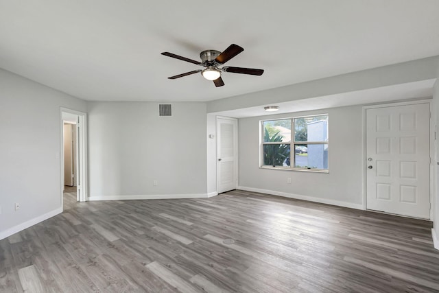 empty room with hardwood / wood-style floors and ceiling fan