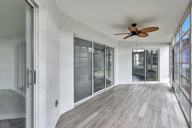 3200 SE Aster Ln Unit S-102, Stuart, FL 34994 - unfurnished sunroom featuring a textured wall, healthy amount of natural light, and wood finished floors
