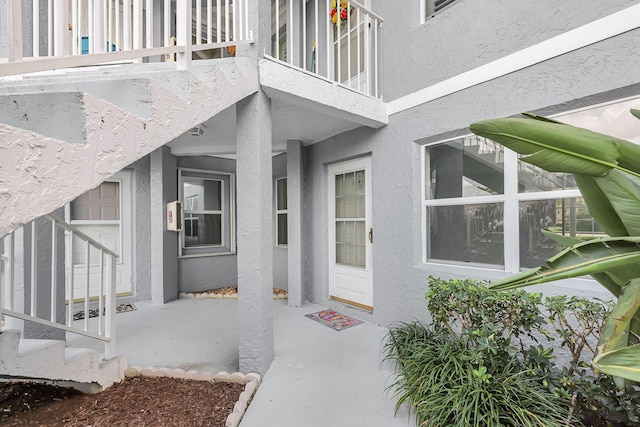 3200 SE Aster Ln Unit S-102, Stuart, FL 34994 - doorway to property with stucco siding and a balcony