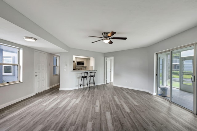 living room with ceiling fan and dark wood-type flooring