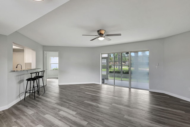 kitchen with dishwasher, sink, dark wood-type flooring, light stone counters, and white cabinets