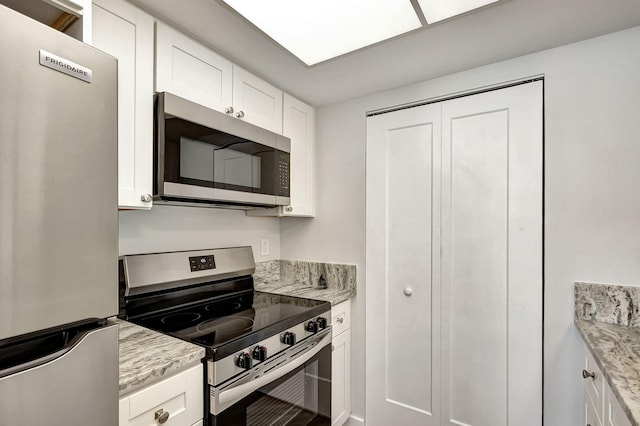 3200 SE Aster Ln Unit S-102, Stuart, FL 34994 - kitchen featuring stainless steel appliances, white cabinets, and light stone counters