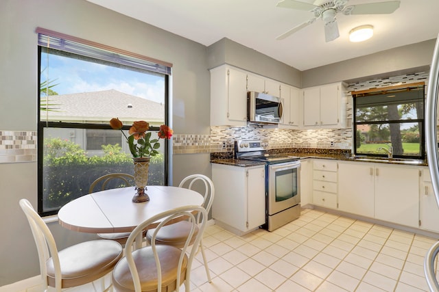 kitchen with decorative backsplash, white cabinets, ceiling fan, sink, and stainless steel appliances