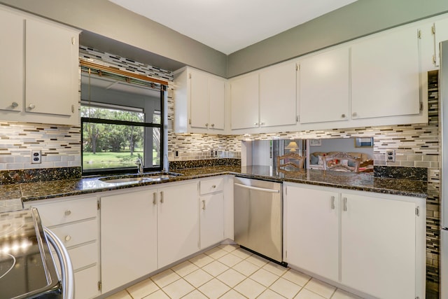 kitchen featuring stainless steel appliances, backsplash, dark stone counters, sink, and white cabinets