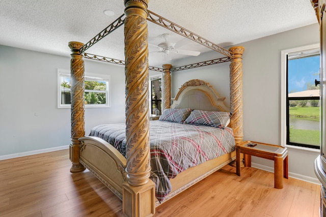 bedroom featuring ceiling fan, wood-type flooring, and a textured ceiling