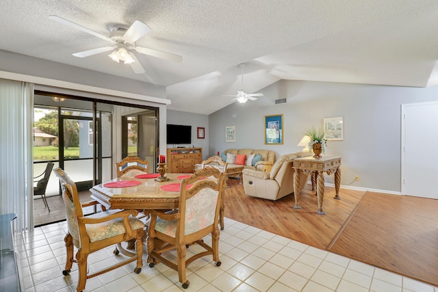 dining space with lofted ceiling, a textured ceiling, light wood-type flooring, and ceiling fan