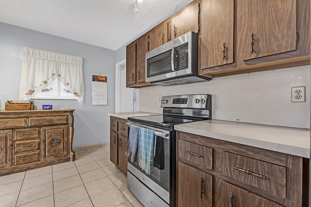 kitchen with light tile patterned floors and stainless steel appliances