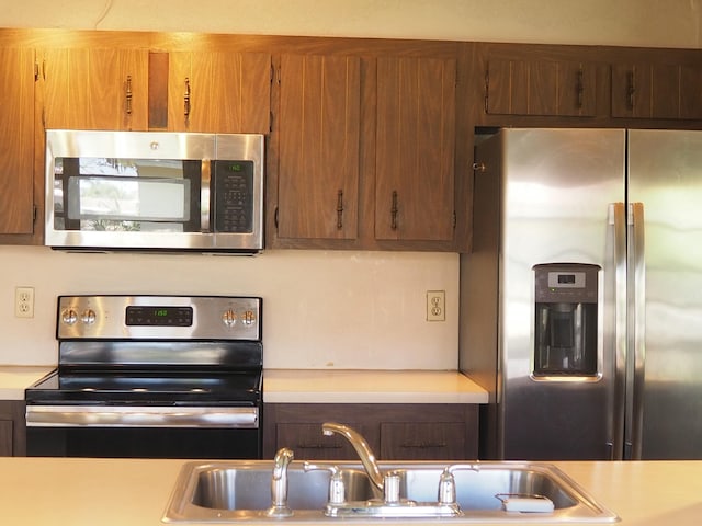 kitchen featuring light countertops, appliances with stainless steel finishes, and a sink
