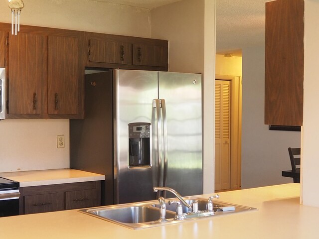 kitchen with light countertops, appliances with stainless steel finishes, and a sink