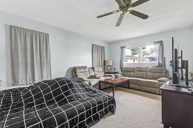 carpeted bedroom featuring ceiling fan and a textured ceiling