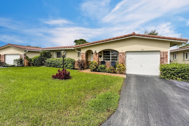 view of front of home with brick siding, stucco siding, an attached garage, and a front yard