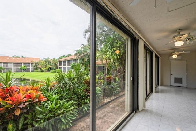 unfurnished sunroom featuring ceiling fan