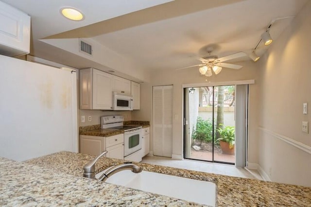 kitchen with light stone counters, ceiling fan, white appliances, rail lighting, and white cabinetry