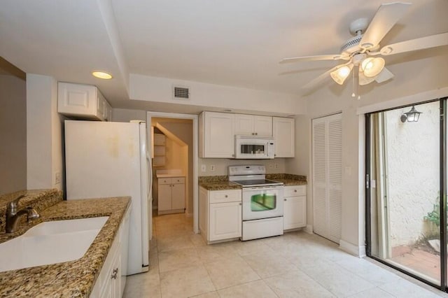 kitchen featuring sink, white appliances, and white cabinetry