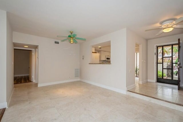 unfurnished room with ceiling fan and light tile patterned flooring