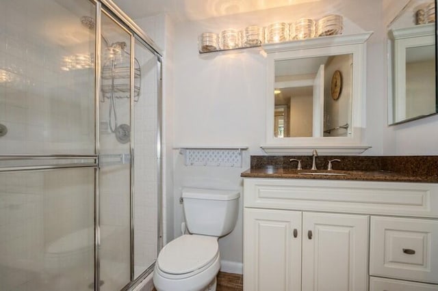 bathroom with vanity, toilet, and an enclosed shower