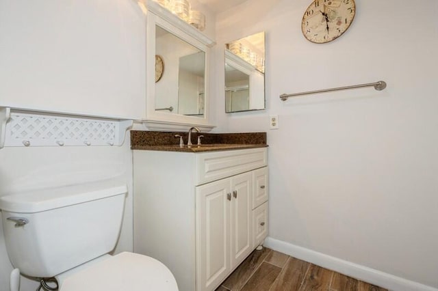 bathroom featuring vanity, hardwood / wood-style flooring, and toilet