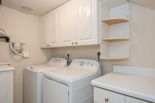 laundry room featuring washing machine and dryer and cabinets