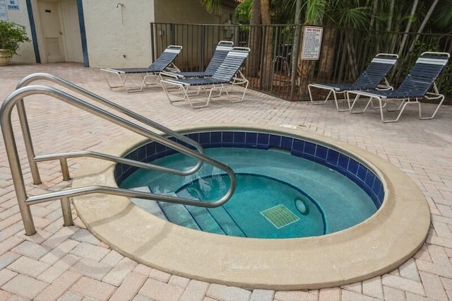 view of swimming pool featuring a patio and a hot tub