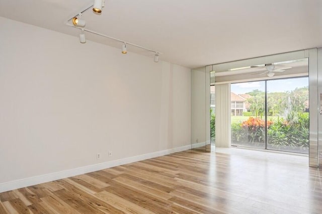 unfurnished room with light wood-type flooring and track lighting