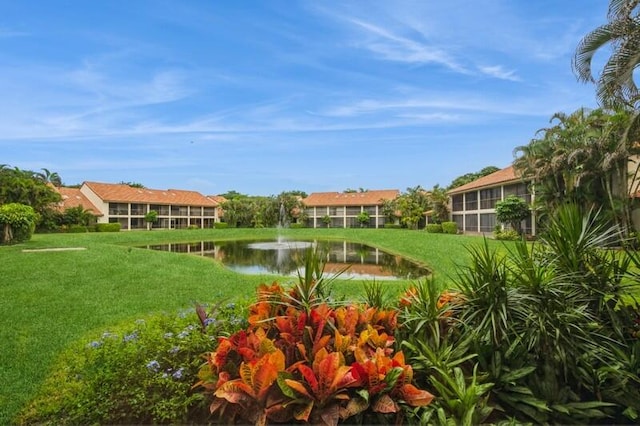 view of community with a water view and a lawn