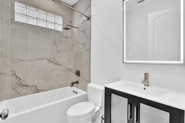 full bathroom featuring vanity, tiled shower / bath, and toilet