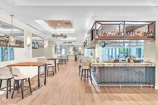 bar featuring crown molding, wood-type flooring, pendant lighting, and tile walls