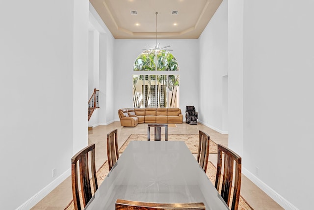 dining space featuring a raised ceiling and ceiling fan