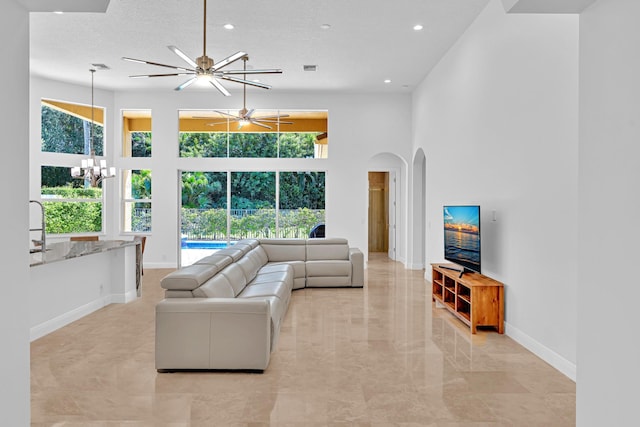 living room featuring a textured ceiling, a towering ceiling, and plenty of natural light