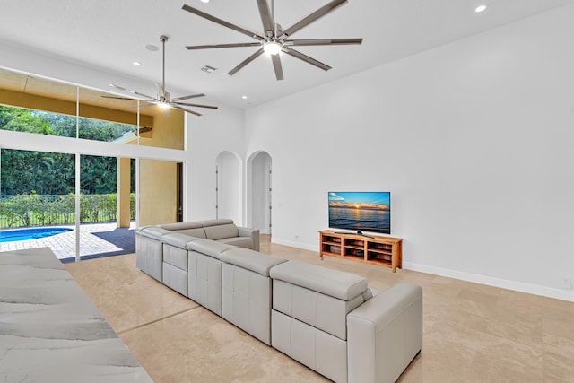 living room featuring a high ceiling and ceiling fan