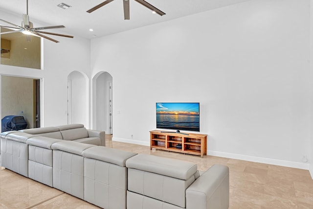 living room with a towering ceiling and ceiling fan