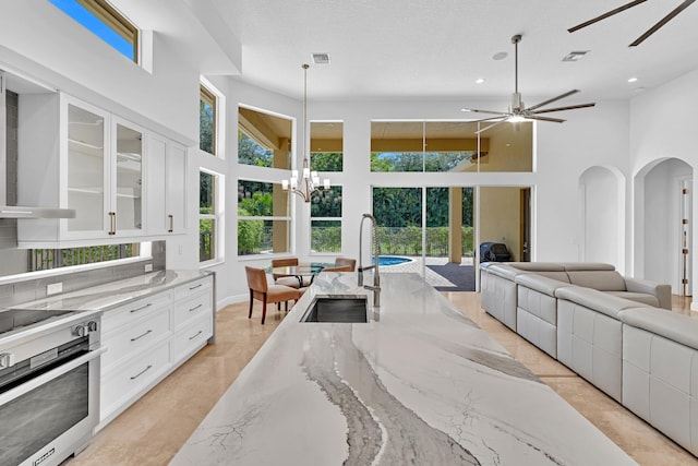 kitchen with white cabinets, light stone counters, and plenty of natural light