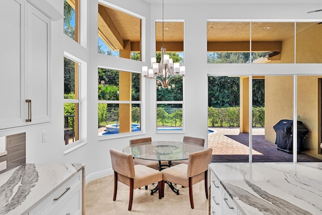 sunroom / solarium featuring a notable chandelier and beam ceiling