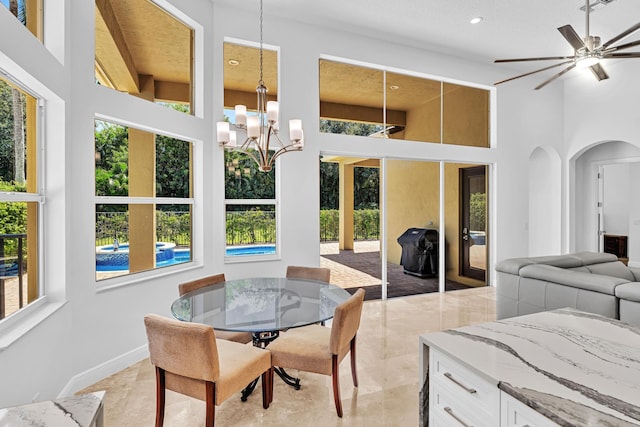 interior space featuring beam ceiling and ceiling fan with notable chandelier